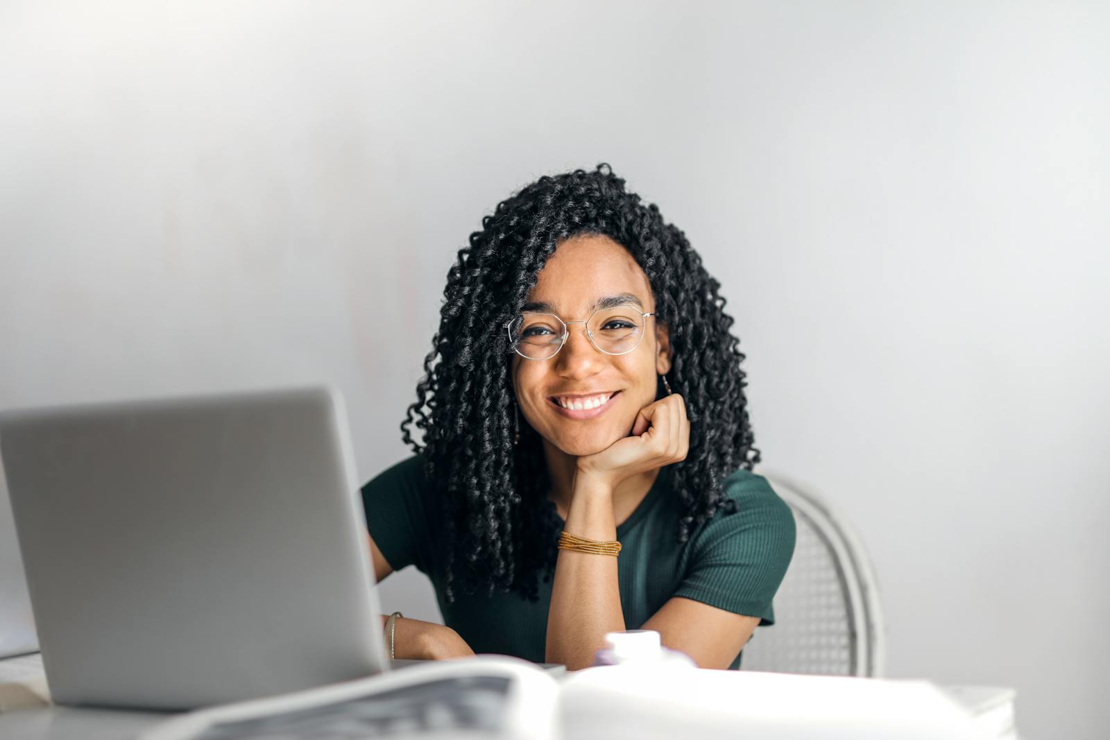 Photo by Andrea Piacquadio Happy ethnic woman sitting at table with laptop
